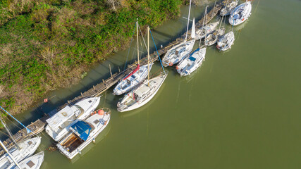 Fototapeta na wymiar Aerial view of many small boats moored along a river.