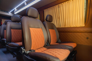 comfortable passenger bus interior with upholstered seats; individual transfer for a group of people; conversion of the interior of a truck; 