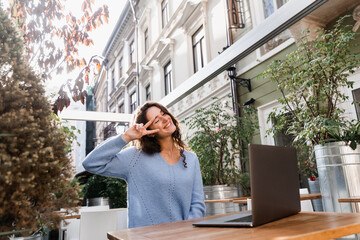 Happy young business woman is chatting with colleagues and have video conference. Girl blogger with laptop is chatting online with her subscribers via video connection.