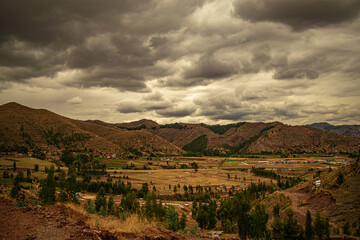 Naklejka premium trees near mountains with cloudy sky in the background in cusco, peru