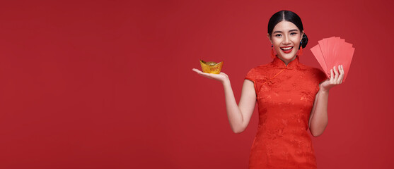 Happy Chinese new year. Asian woman holding angpao or red packet monetary gift and gold ingot...