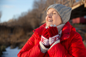 portrait of a cheerful senior woman   in winter nature. Enjoying the little things. Winter Vibes. christmas holiday. copy space