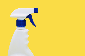 Plastic white spray bottle on a yellow background. Detergent for cleaning and disinfection when...
