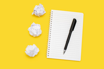 Notebook and pen with crumpled sheets on a yellow background. Notepad with blank sheets and free...