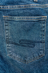 Blue trendy jeans close-up with back pocket view. Denim background and fabric texture. Free space for text. Wide leg indigo jeans. Close-up of the back pocket of jeans in a vertical image