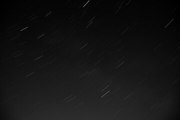 Astronomical long exposure photography of stars with star trails and a meteor or shooting star