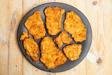 chicken breast fried with eggs on a black plate