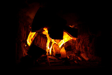 burning firewood in the oven closeup, cozy warmth by the fireplace