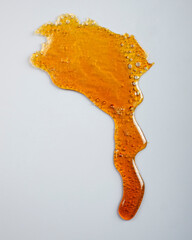 amber cannabis resin on gray background, thc wax rosin