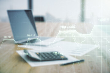 Multi exposure of creative statistics data hologram on blurry calculator with laptop background, stats and analytics concept