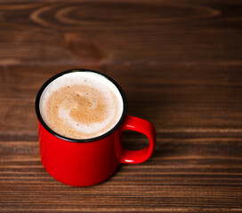 Red cup with cocoa on wooden background