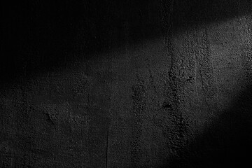 Black wall rough texture background, concrete floor or old grunge backdrop, illuminated by sun ray....