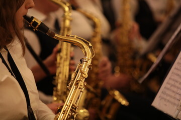 Woman playing the saxophone sitting in the orchestra