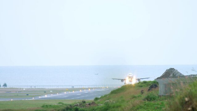 Front view of passenger plane descending before landing. Runway on the background of the sea