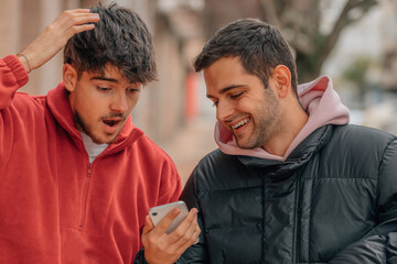 friends on the street looking surprised at the mobile phone