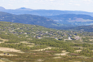 Fototapeta na wymiar View on the mountain huts of the ski village Beitostølen in the norwegian mountains during summer