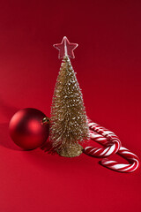 Banner with Christmas decorations on red background with small christmas tree