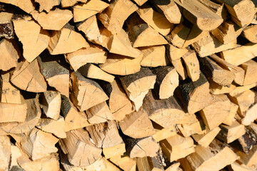 Woodpile lies in a heap, chopped for burning in a furnace. Finely chopped and stacked firewood, background. Laid dry firewood, texture, background. Firewood wall, dry chopped firewood background.