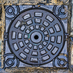 Fototapeta na wymiar A wet manhole cover in the street
