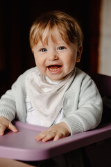 Cute baby looking into camera and laughing, showing two teeth