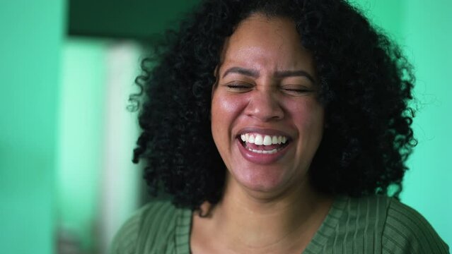 One young black woman laughing out loud portrait face real life laugh and smile
