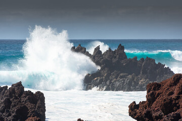 Naklejka na ściany i meble Powerful waves against the sea stacks of Lanzarote island, Atlantic Ocean, Canary Islands in Spain
