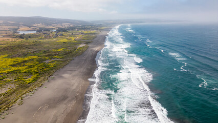 Aerial shot of a beach and the pacific ocean at Pichilemu, Chile