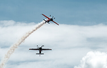 two planes cross dangerously in the blue sky, leaving a trail of white smoke. danger concept