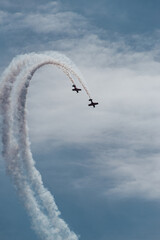two small planes fly in parallel describing a white trajectory over the blue sky. condensation...