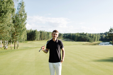 golfer stands with a golf club on a green field. High quality photo