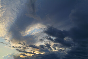 Summer evening sky in the picturesque clouds, lit by the rays of the setting sun.