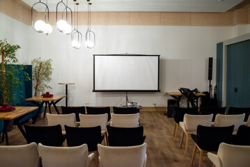 Meeting conference room with blank empty mockup screen for advertising standing in modern contemporary office on wall background. No people. Business technologies concept.