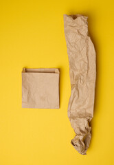 Brown paper craft bags for food packaging on a yellow background