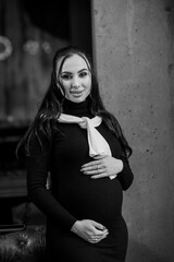 Beautiful young pregnant woman in black dress
