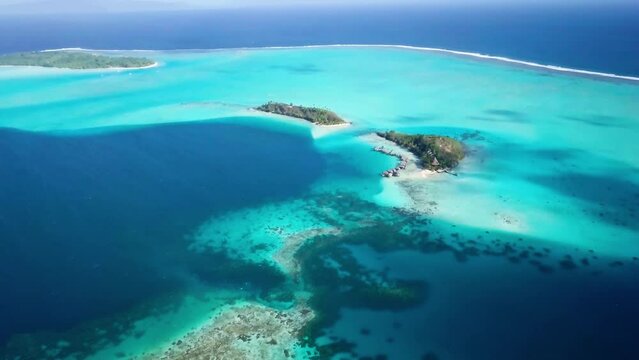 4K Aerial Drone footage of a turquoise blue lagoon in Bora Bora, Tahiti, French Polynesia. Luxury, romantic vacation, honeymoon exotic destination.