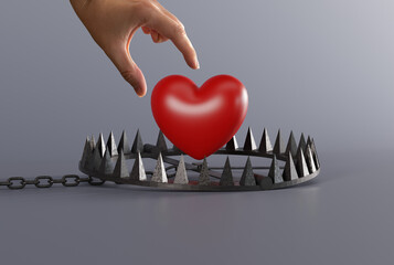 Hand is trying to catch heart over a snare, a trap on a dark background. The concept of being...