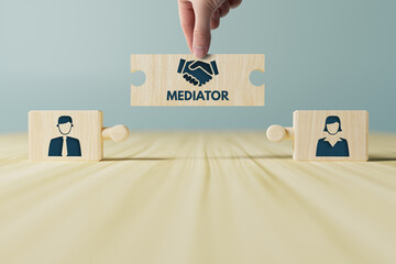 The hand holds wooden wooden blocks with icons of a woman and a man and shaking hands in the act of consent. The concept of divorce, agreement, mediation, the role of the mediator. - obrazy, fototapety, plakaty