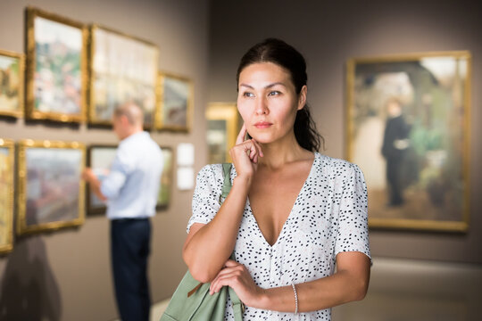 Asian female visitor at exhibition in museum