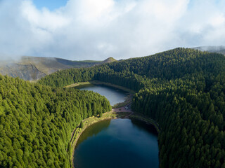 Magical aerial view of the Lake of Empadadas in Sete Cidades, landscape view of the lagoon with a light of sun and some mist. São Miguel island in the Azores. - obrazy, fototapety, plakaty