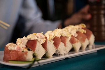 Delicioso plato de sushi acompañado de salsa, chile, zanahoria, sobre un plato blanco