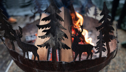 A fire burns in the original metal hearth with figurines of deer and firs