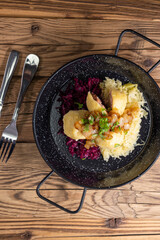 dumpllings filled with smoked meat served with red and white cabbage