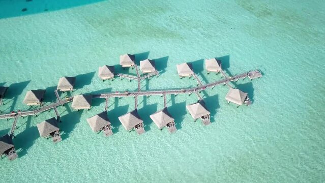 4K Aerial Drone footage of water villa bungalows in Bora Bora, Tahiti, French Polynesia. Turquoise blue lagoon in Bora Bora. Luxury travel vacation, romantic getaway, honeymoon exotic destination