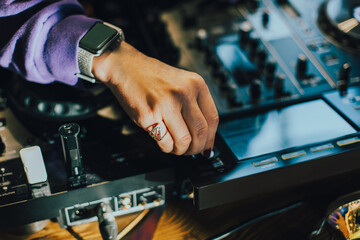 DJ plays live set and mixing music on turntable console on stage at nightclub. Disc Jockey Hands on a sound mixer station at club party. SELECTİVE FOCUS