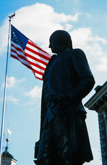 Philadelphia, Pennsylvania, April 14, 2014: A Statue of George Washington with the United States Flag in the Background