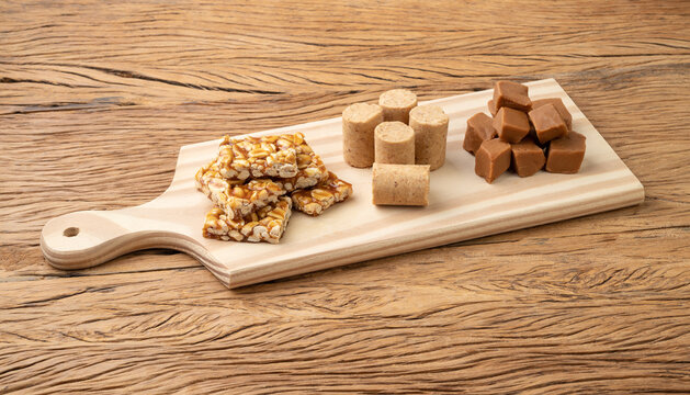 Typical brazilian candies over wooden board. Doce de leite or dulce de leche, pe de moleque and pacoca