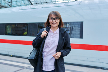 Woman passenger on railway platform inside station - obrazy, fototapety, plakaty