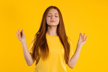 Calm woman relaxing, meditating, refuses stress. Sunny girl breathes deeply, calms down yellow...