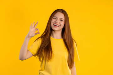 Pretty woman makes hand sign okay, ok gesture. Happy ginger girl, correct perfect choice, great...