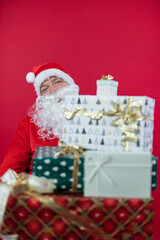 
Portrait von einem verkleideten Weihnachtsmann mit Geschenk, isoliert auf roten Hintergrund im Studio